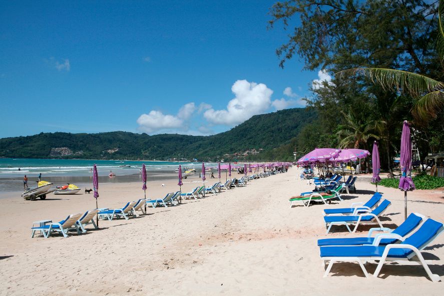 a small white boat floating on patong beach